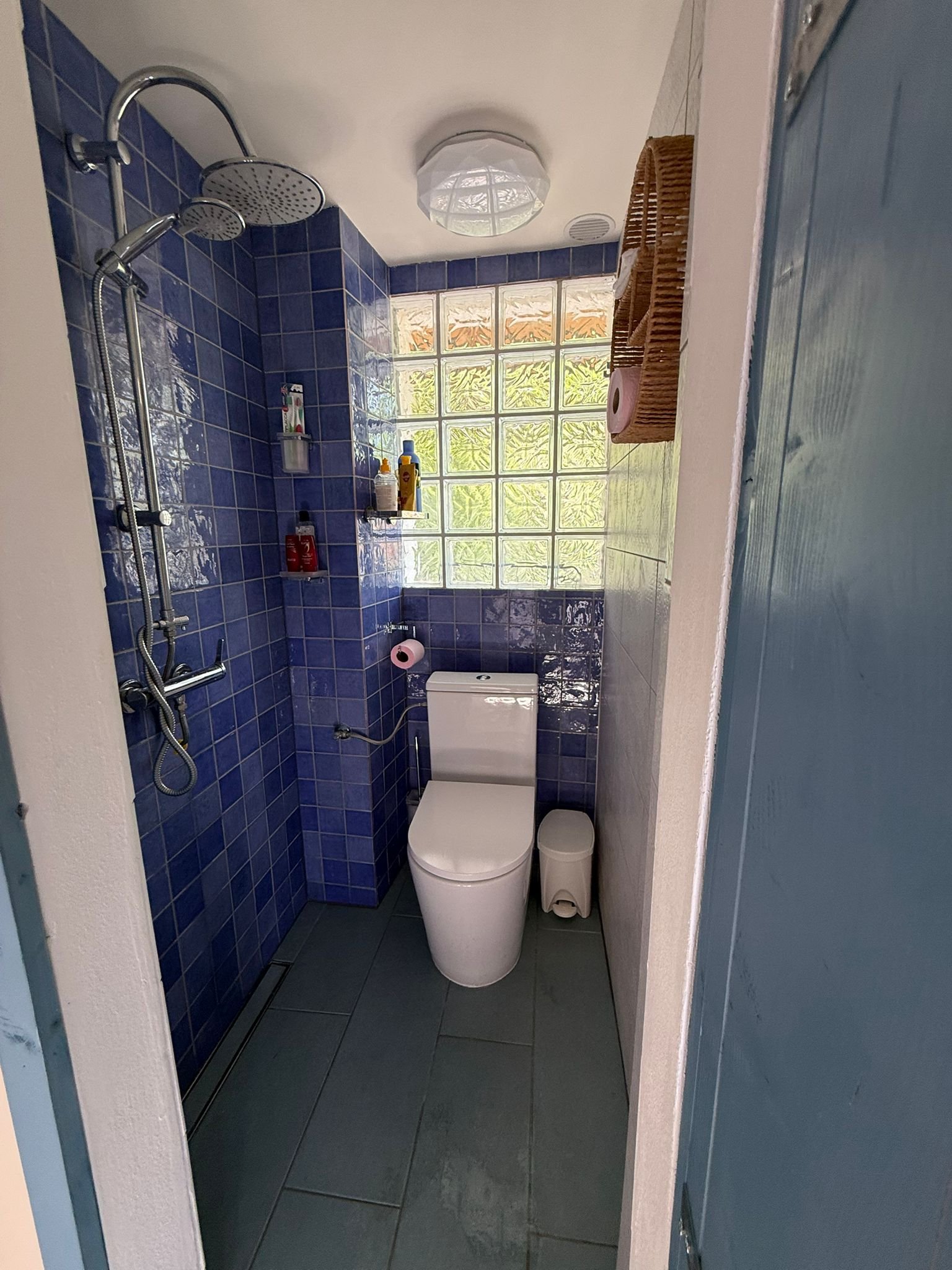 Badkamer met blauwe tegels en douche
